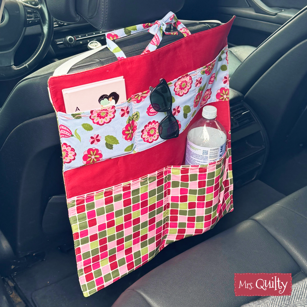 The Car Organizer Downloadable PDF Quilt Pattern lets you sew a colorful organizer that hangs on the back of a car seat—ideal for holding water bottles, sunglasses, and notebooks to keep your essentials tidy while traveling.