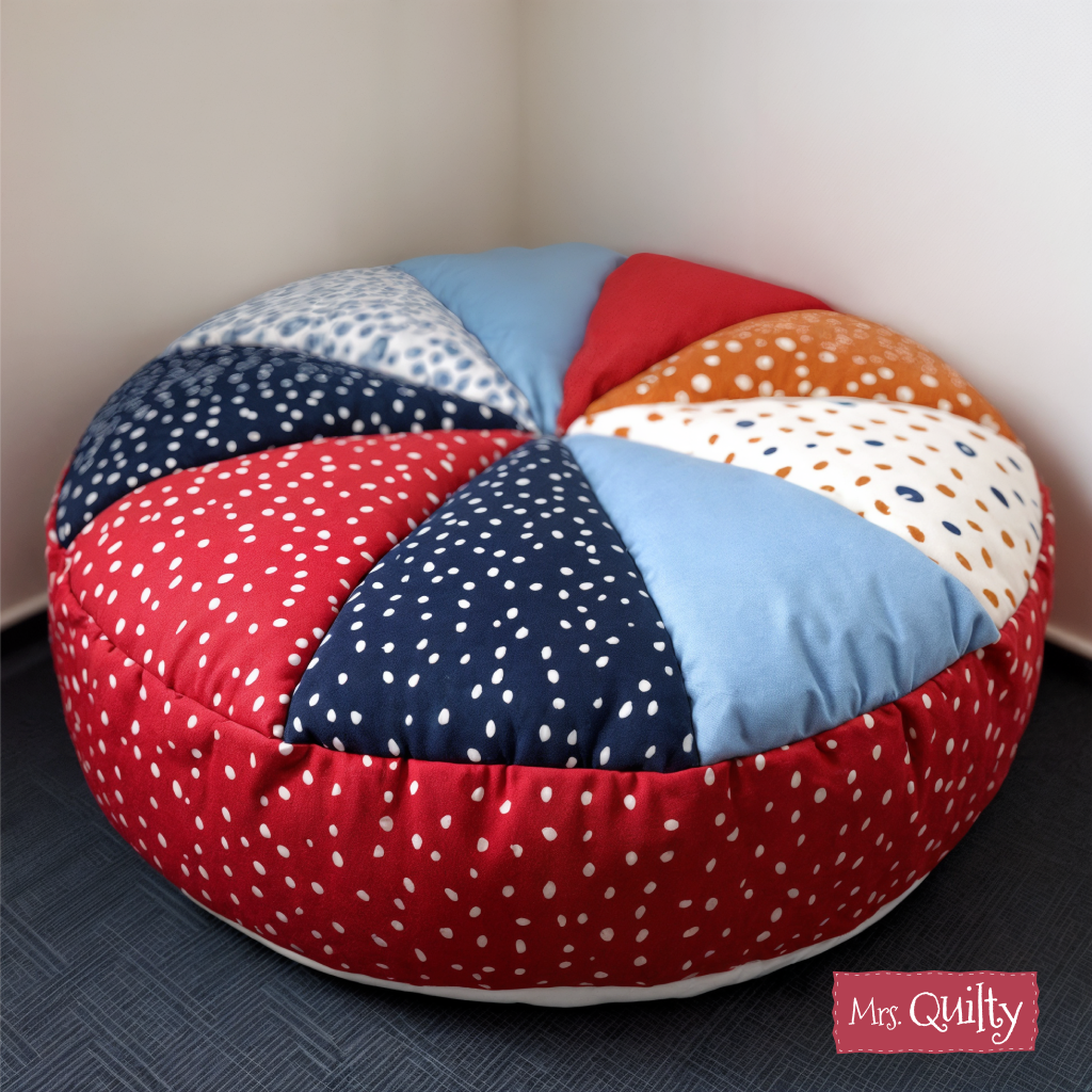 A round, multicolored patchwork cushion featuring polka dot and solid patterns sits in a room corner. The "Mrs. Quilty – Summer Bundle of 7 Quilted Patterns" offers beginner-friendly designs for creative quilted projects.