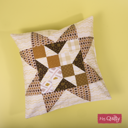 The Decorative Cushion Cover Downloadable PDF Quilt Pattern features a brown and cream geometric star on yellow, with a "Mrs. Quilty" logo in the corner. Includes an easy-to-follow digital quilting pattern for crafting your own cushion cover.