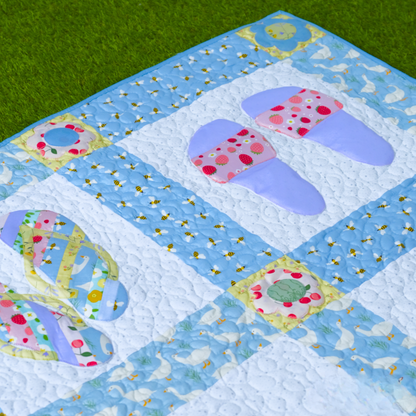 The Flip Flop Quilt Downloadable PDF Quilt Pattern features colorful, circular pastel designs—perfect for beginners and shown here displayed on green grass.