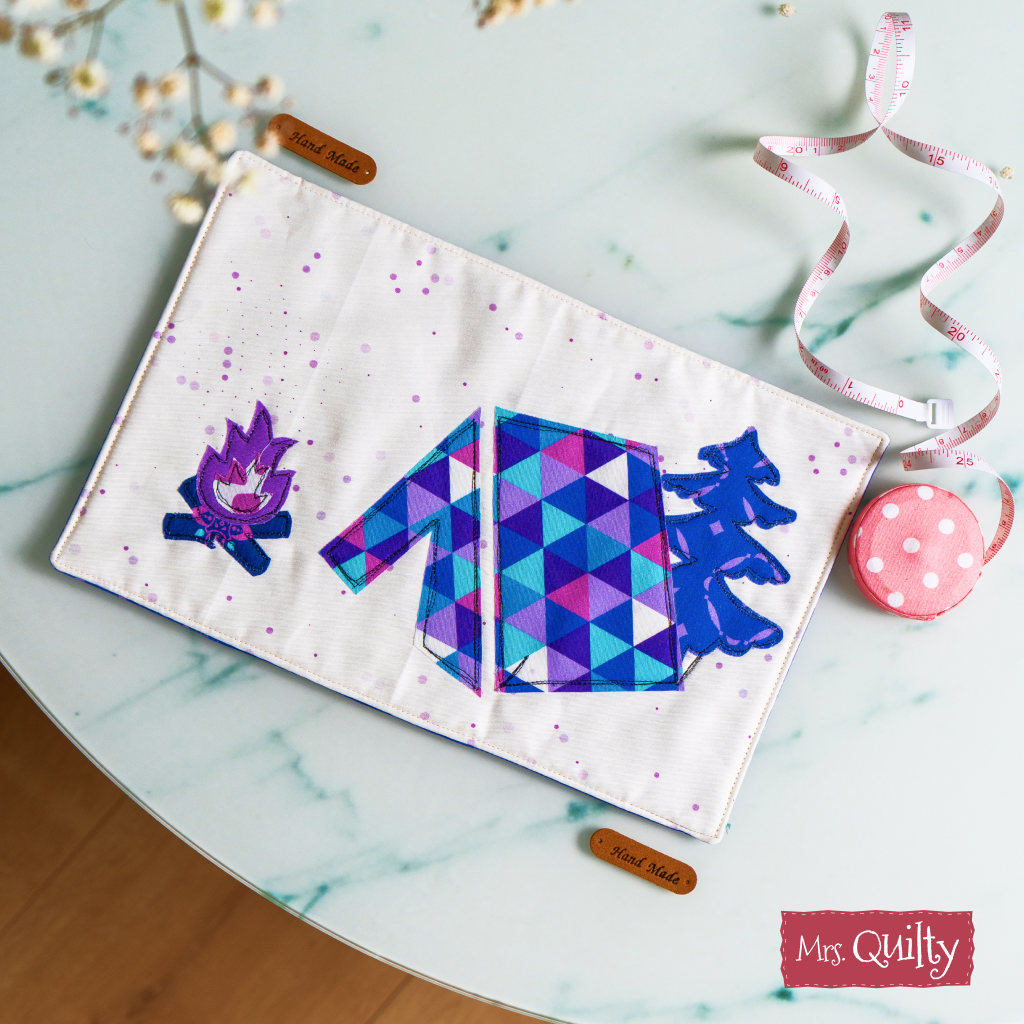 The Hiking Mug Rug Downloadable PDF Quilt Pattern creates a geometric, nature-inspired decorative piece—perfect for brightening up a light surface in your home or sewing space.