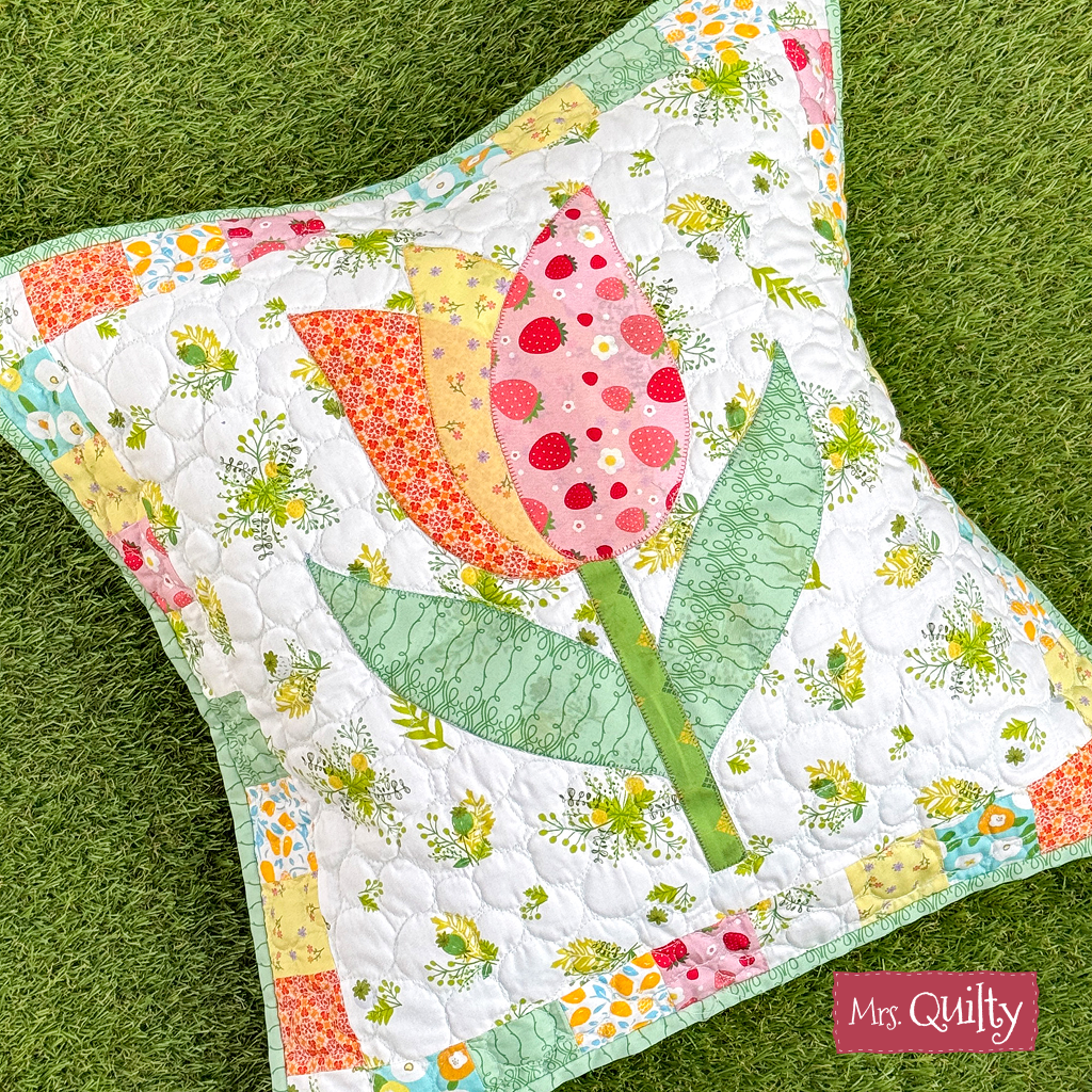 Tulip Pillows Downloadable PDF Quilt Pattern—create a square pillow with a patchwork tulip design in pink, yellow, and green. Label reads "Mrs. Quilty." Ideal beginner project for soft toy-making or Patchwork Puppy fans.