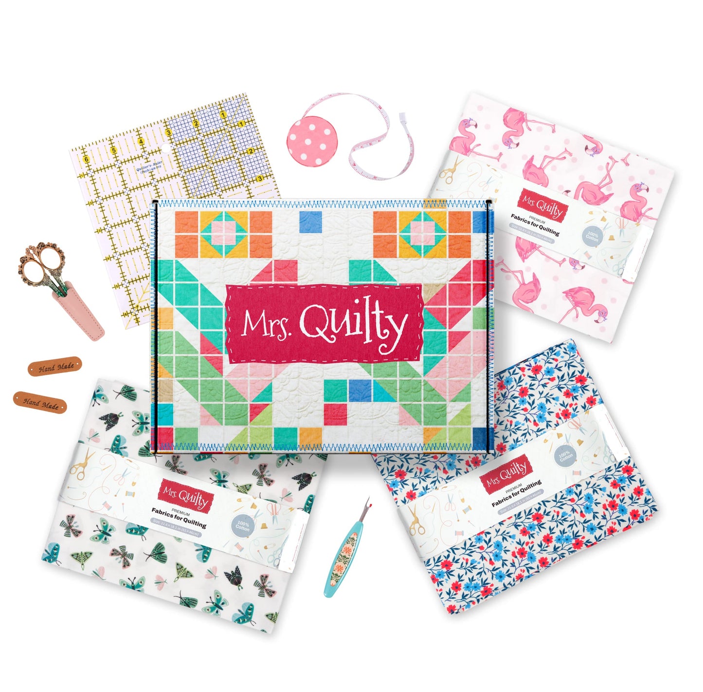The Mrs Quilty Subscription Box includes colorful quilting supplies such as pattern booklets, scissors, measuring tape, thread cutter, and labels.