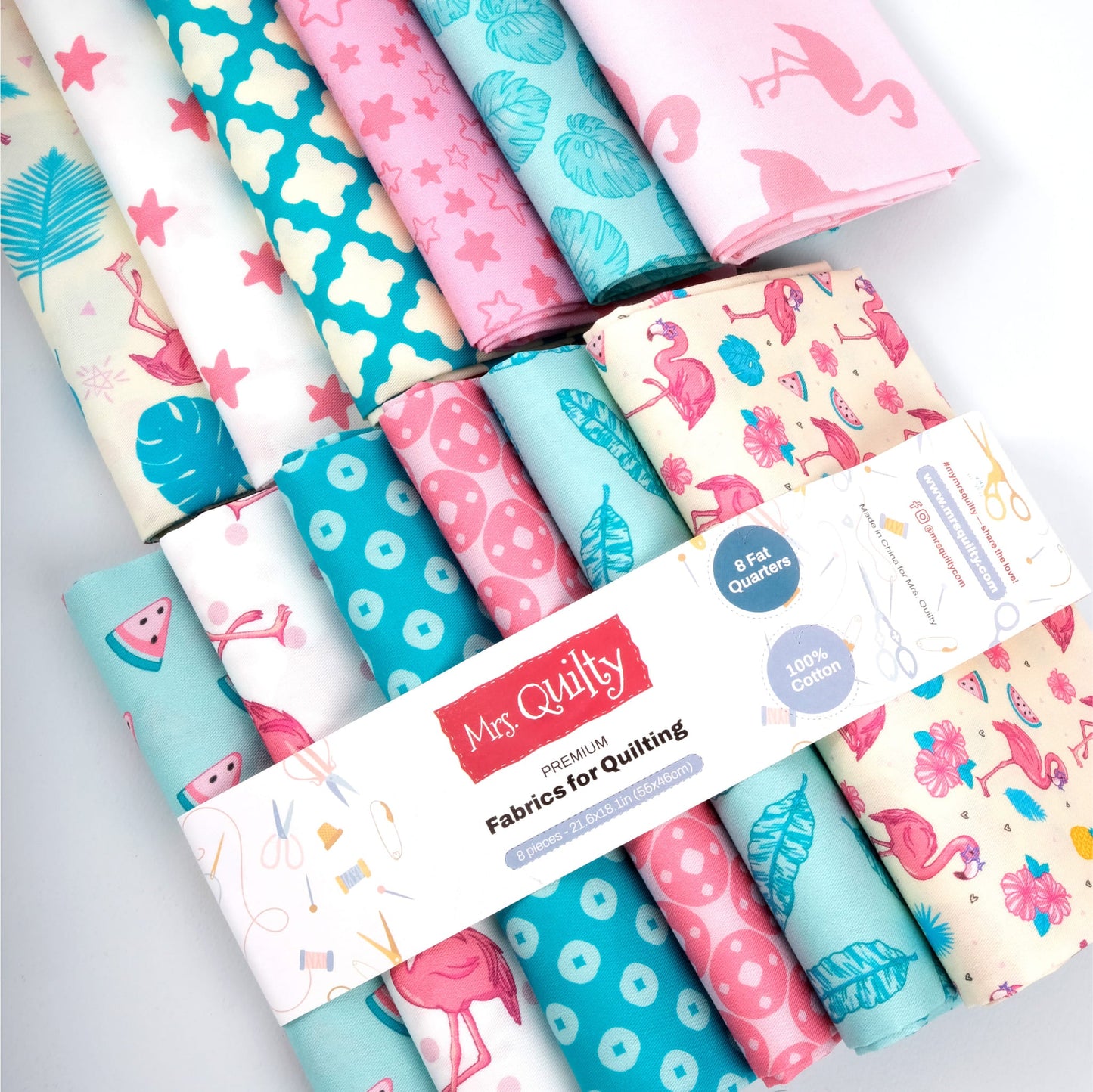 A bundle of vibrant quilting fabrics featuring flamingos, watermelon slices, polka dots, and abstract designs. The label states "Mrs Quilty Subscription Box: Premium Fabrics for Quilting.